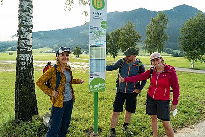 Drei Fahrgäste warten auf den Ringbus am Goymoos Kreisverkehr bei Rettenberg.